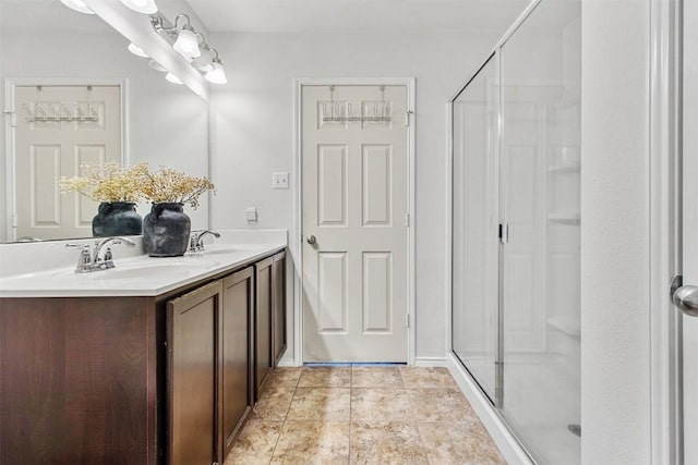 full bathroom with double vanity, tile patterned flooring, a shower stall, and a sink