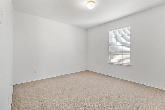 empty room featuring carpet and baseboards