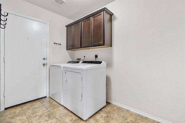 washroom with washer and clothes dryer, cabinet space, visible vents, and baseboards