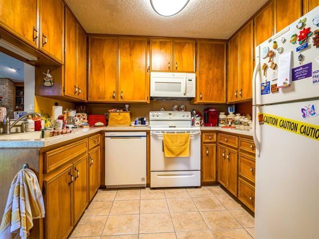 kitchen with light countertops, white appliances, and brown cabinetry