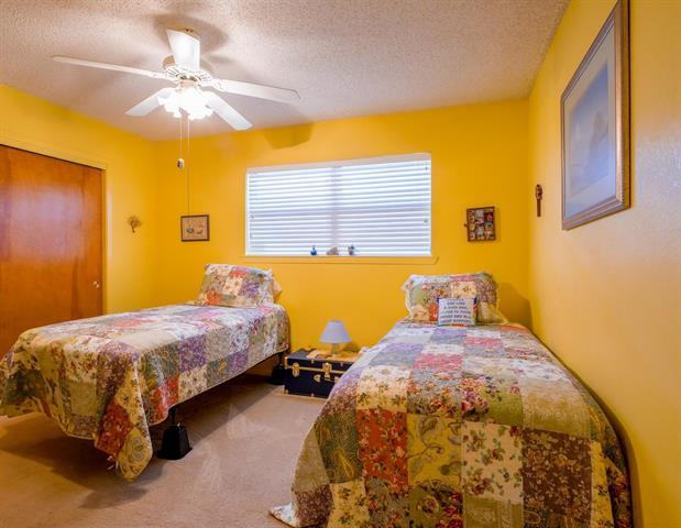 carpeted bedroom featuring ceiling fan, a closet, and a textured ceiling