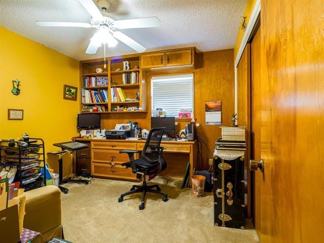 office space with a ceiling fan, carpet, and a textured ceiling