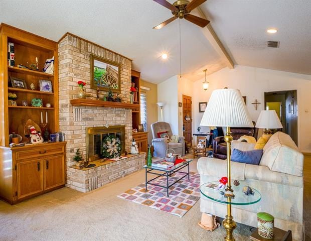 carpeted living room with lofted ceiling with beams, a brick fireplace, visible vents, and a ceiling fan