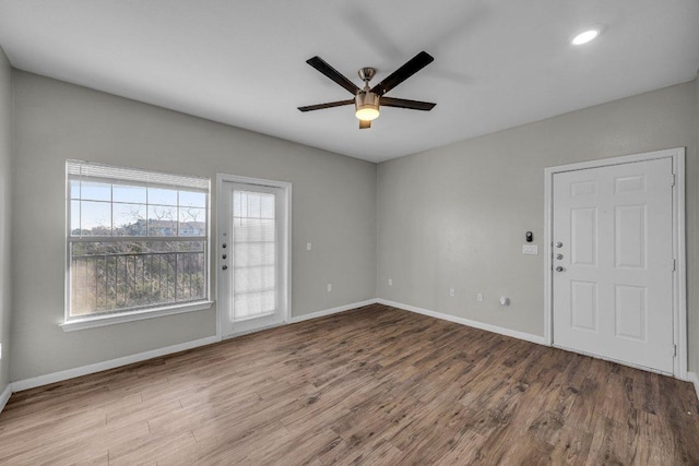 spare room featuring ceiling fan, baseboards, and wood finished floors