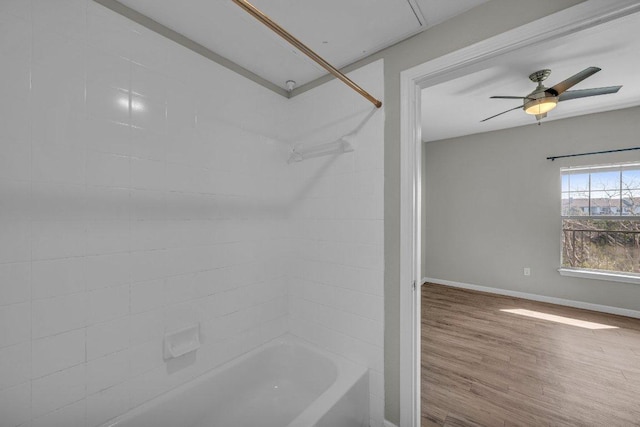 bathroom with a ceiling fan, shower / tub combination, baseboards, and wood finished floors