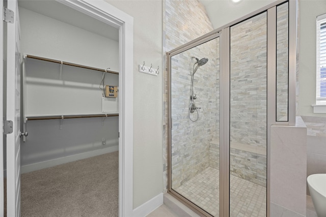 full bathroom with a shower stall and a spacious closet