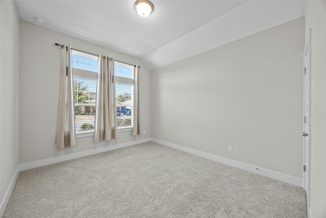 unfurnished room with carpet, lofted ceiling, and baseboards