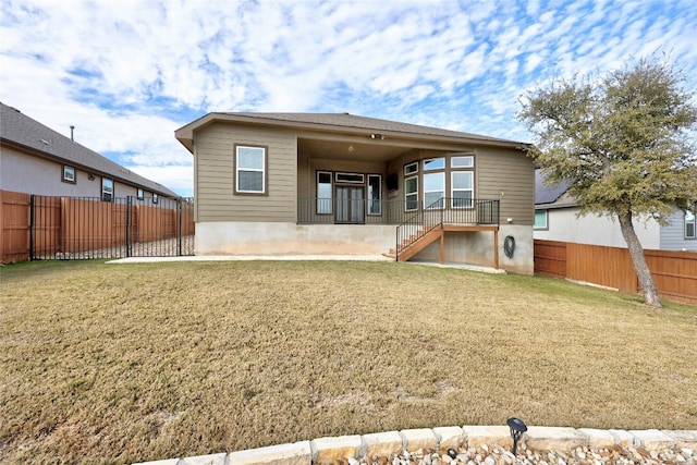 back of house featuring a yard, stairway, and a fenced backyard