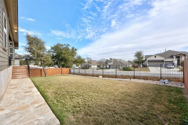 view of yard with a residential view and a fenced backyard