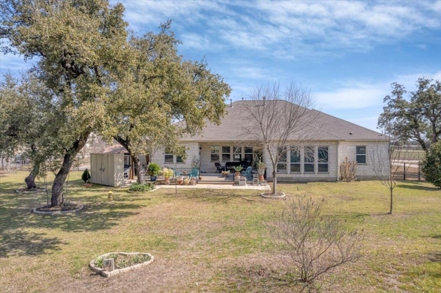 rear view of house featuring a storage shed, a patio, an outdoor structure, and a lawn