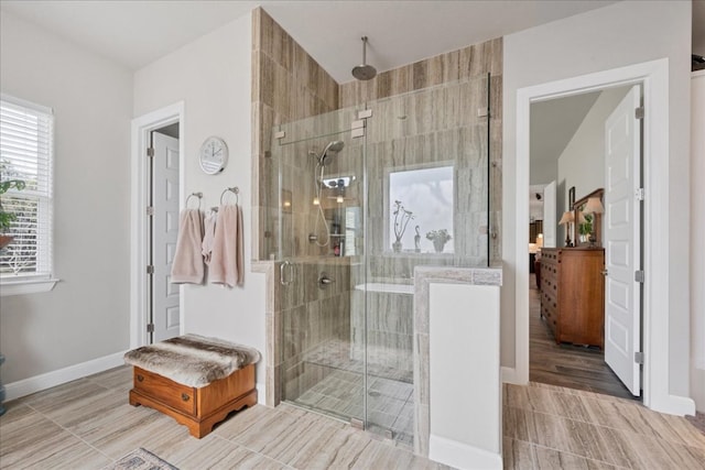 full bath featuring a shower stall and baseboards