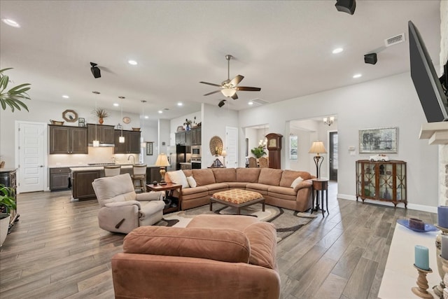 living area featuring ceiling fan, baseboards, wood finished floors, and recessed lighting