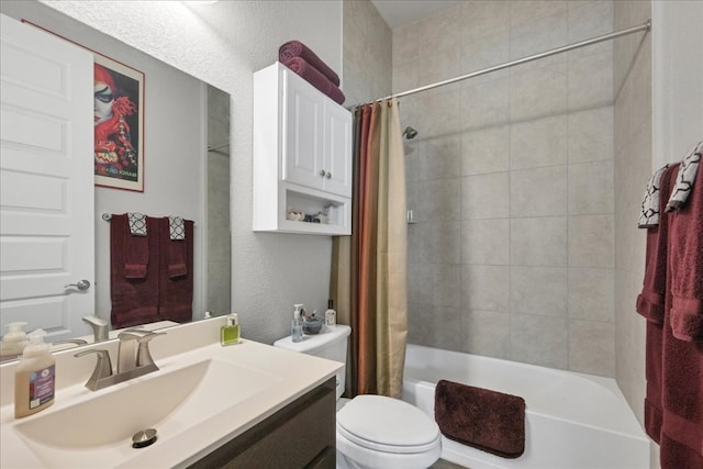 full bath with a textured wall, shower / bath combo, vanity, and toilet