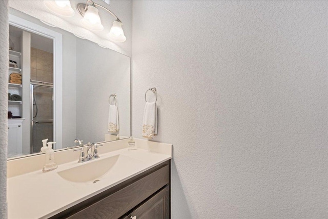 bathroom featuring a textured wall and vanity