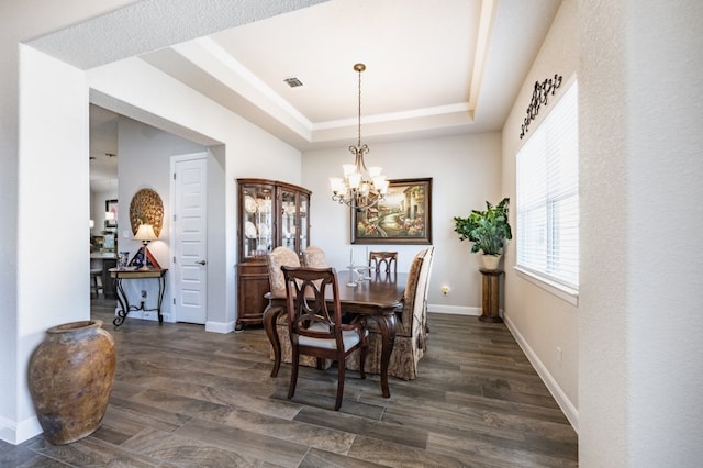 dining area featuring baseboards, visible vents, a raised ceiling, dark wood finished floors, and a chandelier