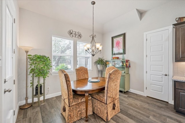 dining room featuring dark wood-style floors, baseboards, and an inviting chandelier