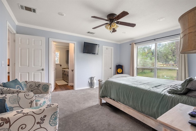 carpeted bedroom with baseboards, visible vents, and crown molding