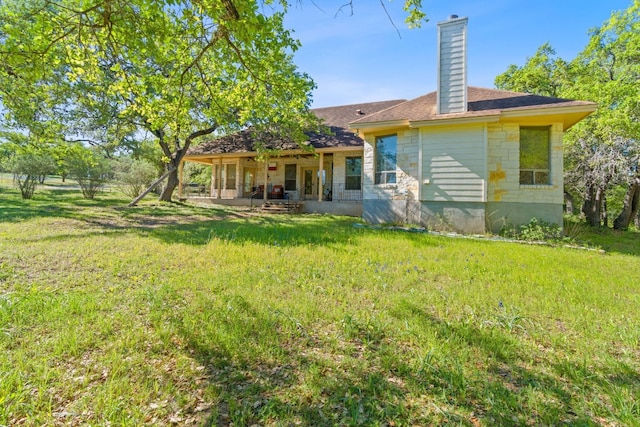 10221 David Moore Dr Unit 1 & 2, Austin, TX 78748 - rear view of house with stone siding, a chimney, and a yard