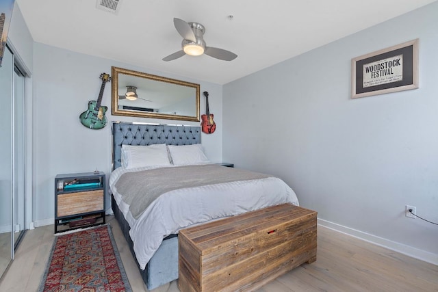 bedroom with visible vents, baseboards, a closet, and wood finished floors