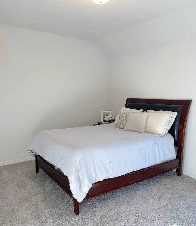 bedroom featuring carpet floors, baseboards, and lofted ceiling