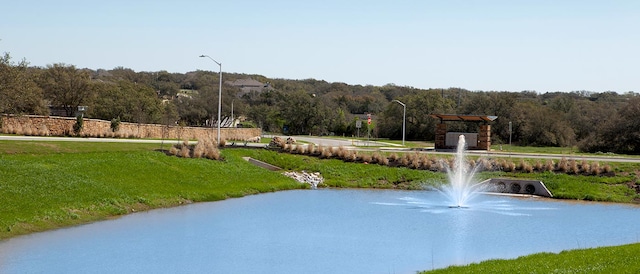 surrounding community featuring a lawn and a water view