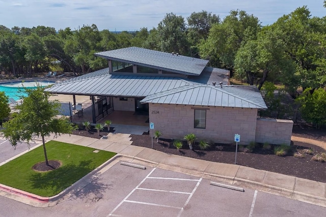 1408 Jolie Rose Bnd, Leander, TX 78641 - rear view of house with uncovered parking, metal roof, a yard, and a standing seam roof