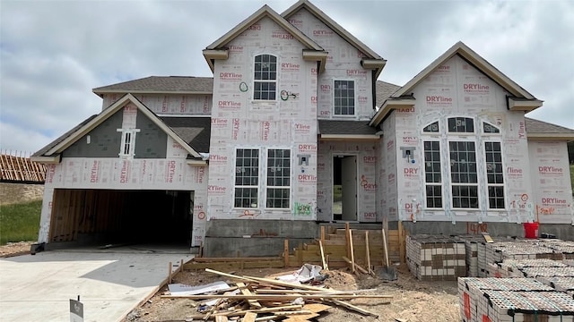 1408 Jolie Rose Bnd, Leander, TX 78641 - unfinished property featuring concrete driveway, stone siding, a shingled roof, and a garage