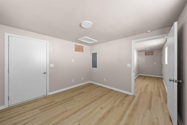 unfurnished room featuring light wood-type flooring, electric panel, and baseboards