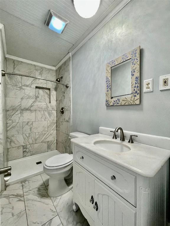 908 W Hopkins St, San Marcos, TX 78666 - bathroom with ornamental molding, marble finish flooring, toilet, vanity, and a tile shower