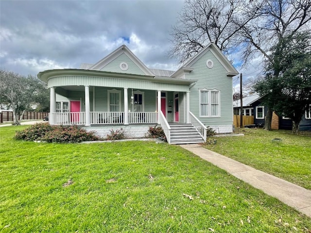 view of front of property with a front yard, covered porch, and metal roof