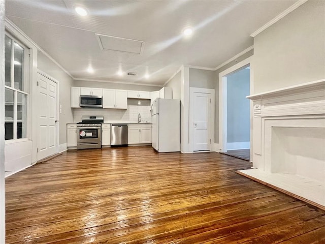 908 W Hopkins St, San Marcos, TX 78666 - unfurnished living room featuring ornamental molding, a sink, attic access, dark wood-style floors, and baseboards