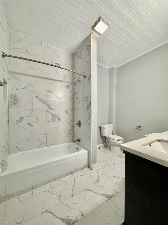 908 W Hopkins St, San Marcos, TX 78666 - bathroom featuring marble look tiles, bathtub / shower combination, vanity, and toilet