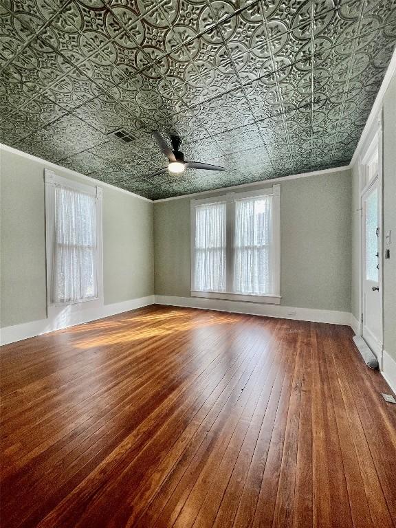 908 W Hopkins St, San Marcos, TX 78666 - unfurnished room with healthy amount of natural light, hardwood / wood-style floors, ceiling fan, an ornate ceiling, and crown molding