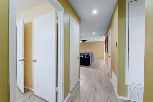 corridor featuring recessed lighting, baseboards, visible vents, and light wood finished floors