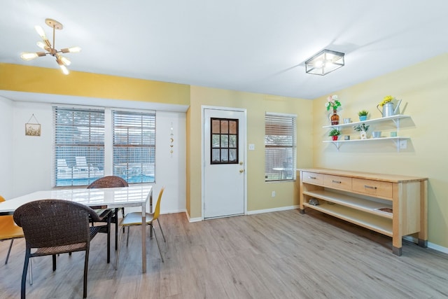 dining area with a notable chandelier, light wood-style flooring, and baseboards