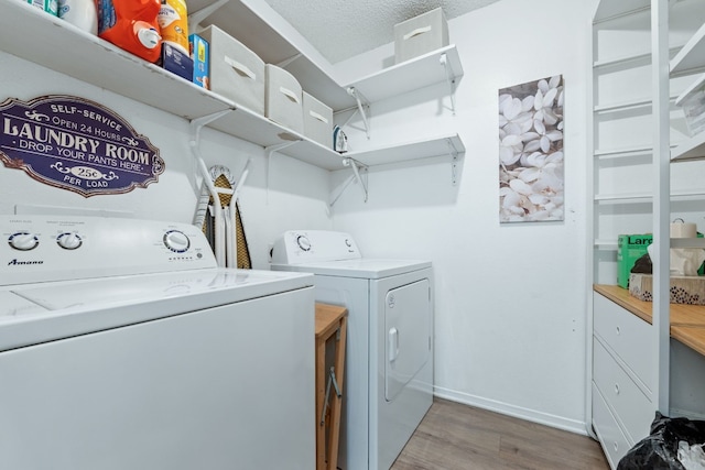 laundry room featuring laundry area, baseboards, wood finished floors, and independent washer and dryer