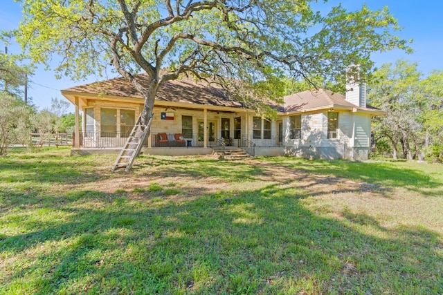 back of house featuring a lawn, a chimney, and a patio