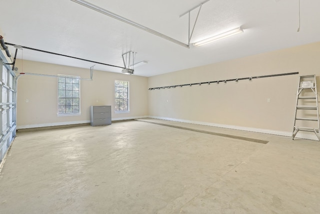 garage featuring a garage door opener and baseboards