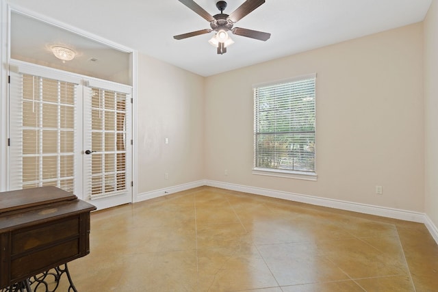 tiled spare room with french doors, a ceiling fan, and baseboards