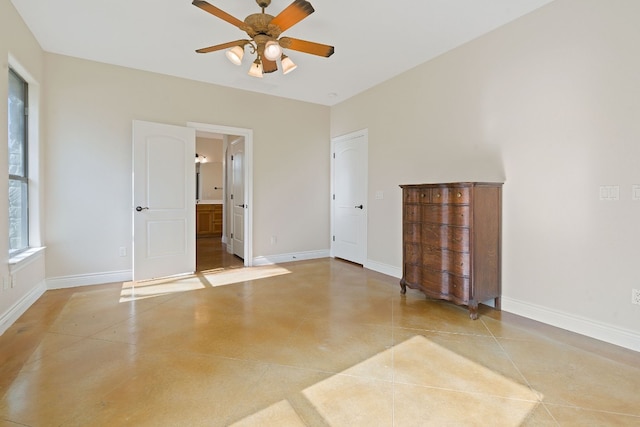 unfurnished bedroom with ceiling fan, baseboards, and connected bathroom