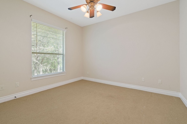 spare room with light carpet, ceiling fan, and baseboards