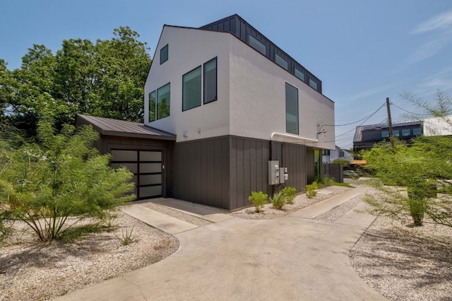 1706 Goodrich Ave Unit A, Austin, TX 78704 - view of home's exterior with a garage, concrete driveway, and board and batten siding