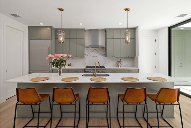 1706 Goodrich Ave Unit A, Austin, TX 78704 - kitchen with wall chimney range hood, gray cabinetry, backsplash, stainless steel built in fridge, and hanging light fixtures