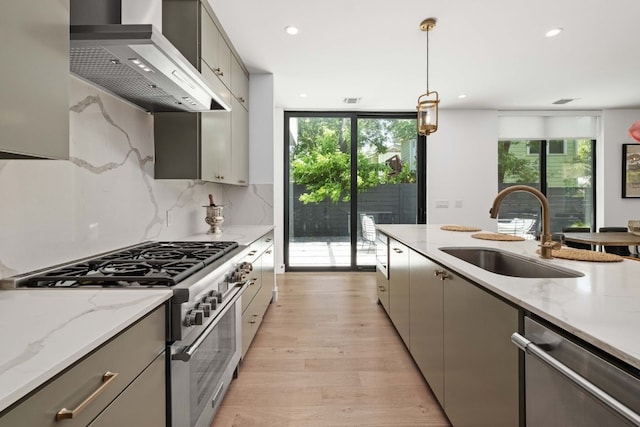 1706 Goodrich Ave Unit A, Austin, TX 78704 - kitchen featuring appliances with stainless steel finishes, wall chimney exhaust hood, gray cabinetry, healthy amount of natural light, and recessed lighting