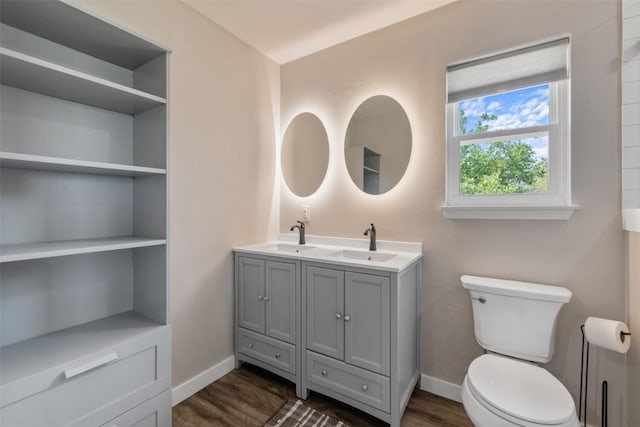 full bathroom with wood finished floors, a sink, toilet, and baseboards