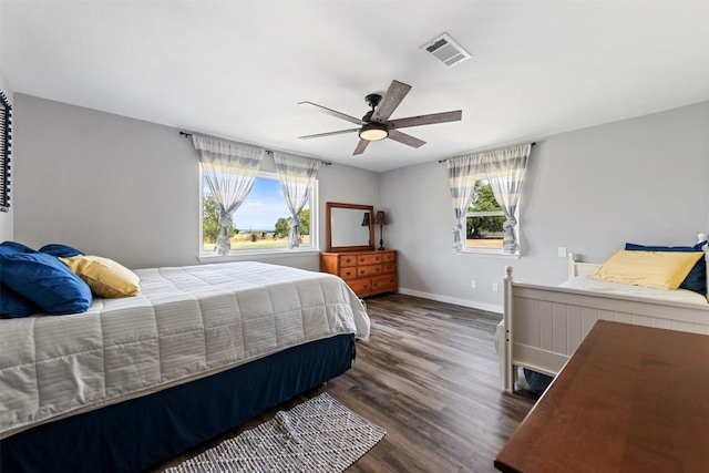 bedroom featuring multiple windows, dark wood finished floors, visible vents, and baseboards