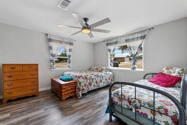 bedroom with visible vents, ceiling fan, baseboards, and wood finished floors