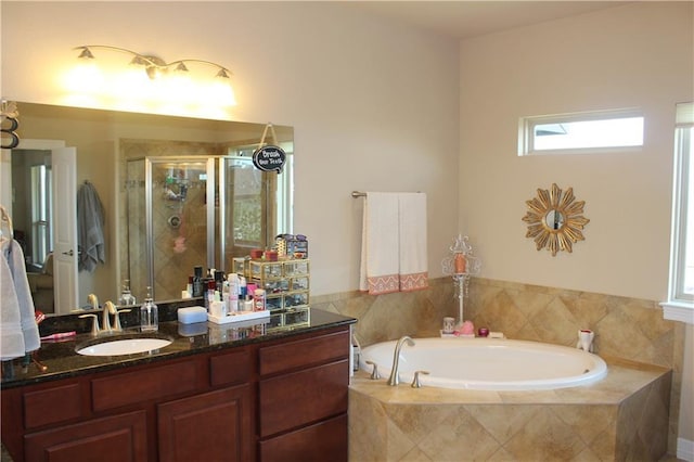 bathroom with a stall shower, a garden tub, and vanity