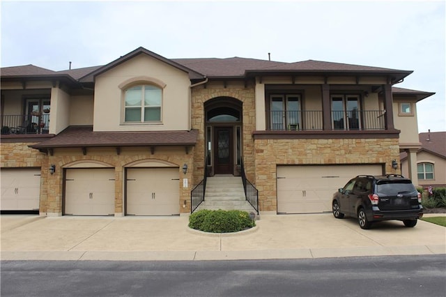 view of front facade with an attached garage, a balcony, driveway, roof with shingles, and stucco siding