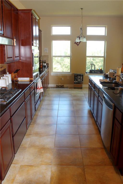 kitchen with stainless steel appliances, dark countertops, a sink, and a healthy amount of sunlight